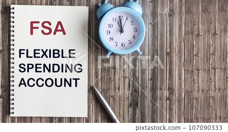 FSA flexible expense account sign on notepad and wooden background FSA flexible expense account sign on notepad and wooden background 107090333