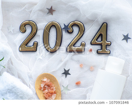 Christmas composition with 2024, towels, sea salt in spoon and body care product 107091846
