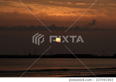 The sun setting on the horizon 107091903