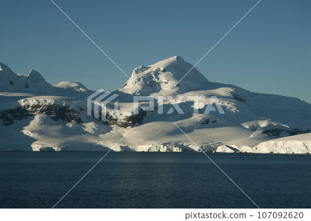 Lemaire strait coastal landscape, mountains and icebergs, Antarctic Peninsula, Antartica. 107092620