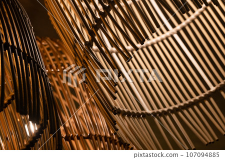 Abstract background photo with straw wooden chandeliers, close up Abstract background photo with straw wooden chandeliers, close up 107094885