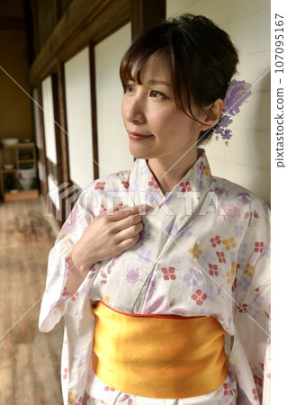 A young woman wearing a yukata in the hallway of an old folk house 107095167