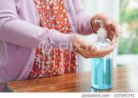 Asian senior woman press blue alcohol sanitizer gel for washing hand protect infection coronavirus. 107095741