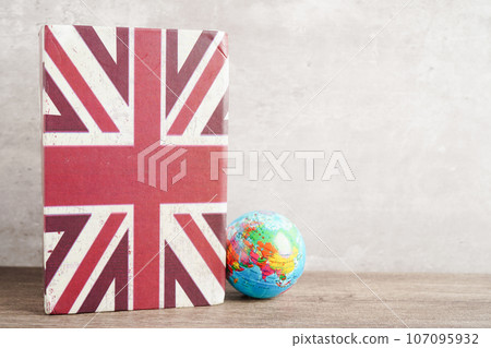 Bangkok, Thailand April 1, 2023 English book and piggy bank with globe, learning and tutorial for foreigner. 107095932