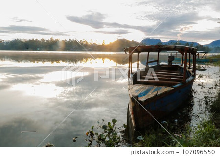 photo of dramatic sunrise view on the lake. with the boat being the foreground. Landscape. Nature. 107096550
