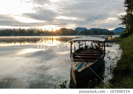 photo of dramatic sunrise view on the lake. with the boat being the foreground. Landscape. Nature. 107096554