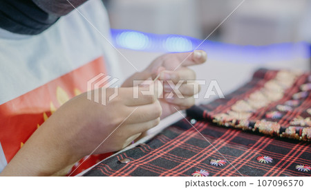 woman is weaving cloth, or so-called traditional tapis cloth, typical of Lampung province, by hand 107096570
