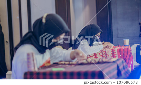 woman is weaving cloth, or so-called traditional tapis cloth, typical of Lampung province, by hand 107096578