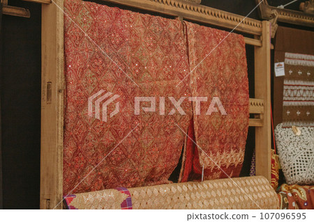 woman is weaving cloth, or so-called traditional tapis cloth, typical of Lampung province, by hand 107096595