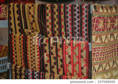woman is weaving cloth, or so-called traditional tapis cloth, typical of Lampung province, by hand woman is weaving cloth, or so-called traditional tapis cloth, typical of Lampung province, by hand 107096600