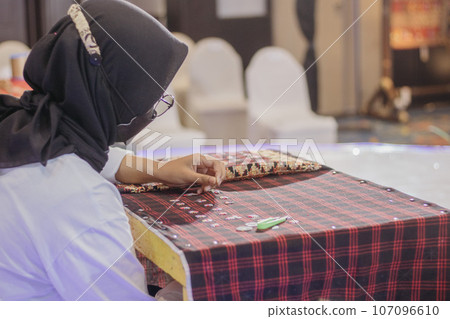 woman is weaving cloth, or so-called traditional tapis cloth, typical of Lampung province, by hand 107096610