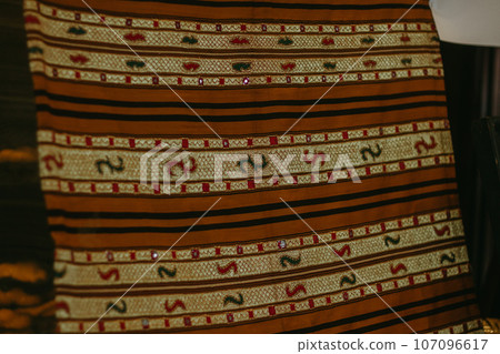 woman is weaving cloth, or so-called traditional tapis cloth, typical of Lampung province, by hand 107096617