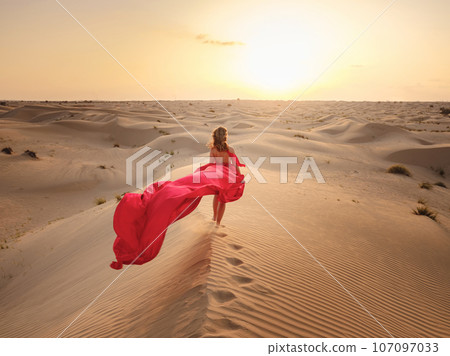 Woman in sands dunes of desert at sunset 107097033
