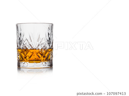 Scotch whiskey in crystal elegant glass on white background with reflection. Scotch whiskey in crystal elegant glass on white background with reflection. 107097413