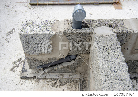Laying a sewer pipe in the bathroom wall during the construction of a house 107097464