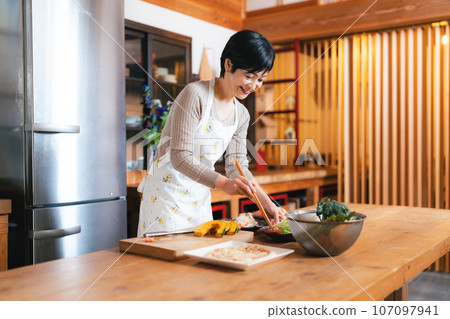 Woman in her 50s making breakfast Woman in her 50s making breakfast 107097941