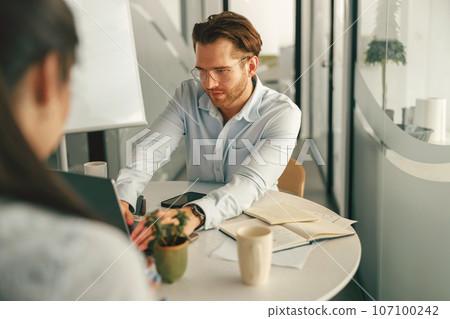 Two diverse business people working in modern coworking space 107100242
