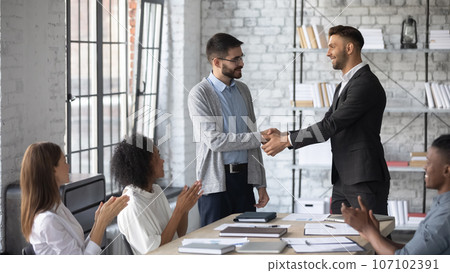 Businessman shake hand of male employee greeting with employment Businessman shake hand of male employee greeting with employment 107102391