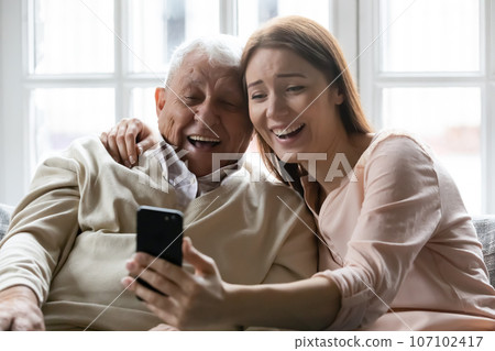 Happy senior father and adult daughter take selfie on cellphone 107102417