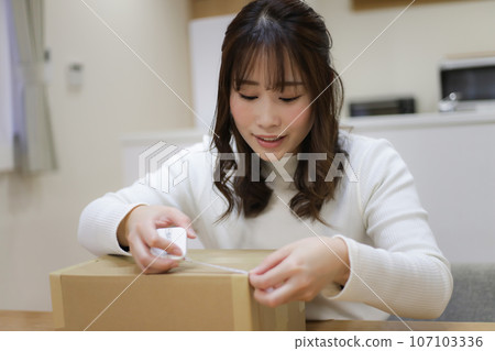 測量紙板箱大小的女人 107103336