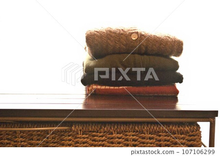 Knitted sweaters stacked on the table 107106299