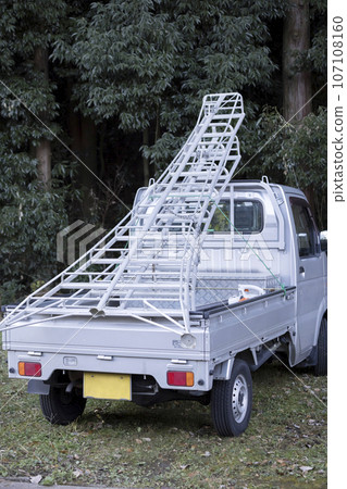 Light truck loaded with a long stepladder for logging work 107108160