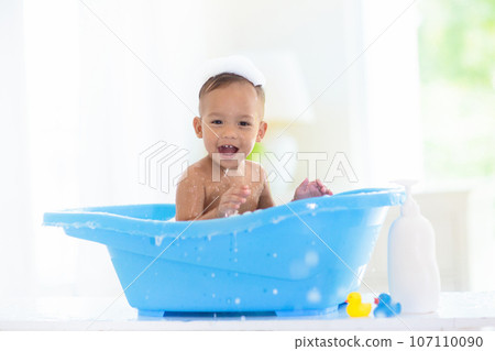 Baby boy in bath. Mother washing infant child. 107110090