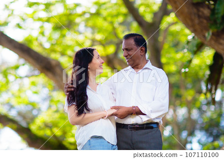 Interracial couple in summer park. Interracial couple in summer park. 107110100