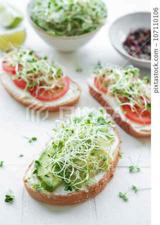 Healthy Eating. Sandwiches with tomatoes, avocado and microgreens. 107110106