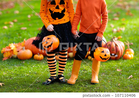 Kids with pumpkins in Halloween costumes 107110406