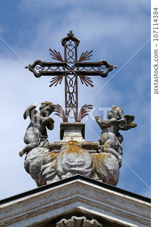 Angels kneeling under the cross, statue on facade of the Mantua Cathedral dedicated to Saint Peter, Mantua, Italy Angels kneeling under the cross, statue on facade of the Mantua Cathedral dedicated to Saint Peter, Mantua, Italy 107114384