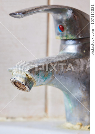 Rusted faucet, macro shot of rusted faucet. Water scarcity and water consumption concept idea. Rusted faucet, macro shot of rusted faucet. Water scarcity and water consumption concept idea. 107115821