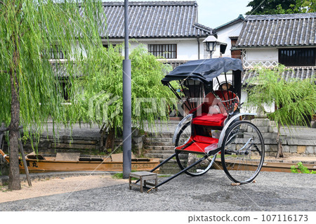 Rickshaw and white-walled mansion in Kurashiki Bikan Historical Quarter, Okayama Prefecture 107116173
