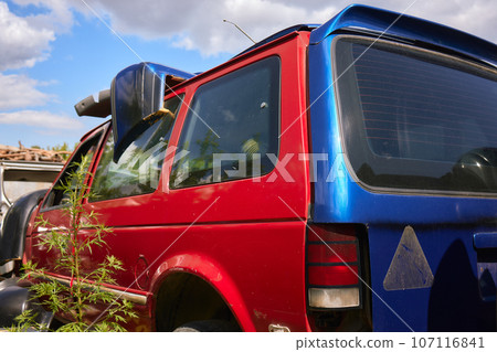 A cropped front view of a burned and abandoned rusty van and broken headlight. A cropped front view of a burned and abandoned rusty van and broken headlight. 107116841