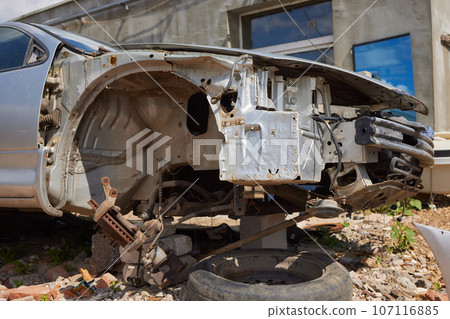 A cropped front view of a burned and abandoned rusty van and broken headlight. A cropped front view of a burned and abandoned rusty van and broken headlight. 107116885