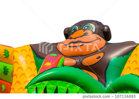 Part of an inflatable large slide is an element for children to ride in the form of a cartoon, funny gorilla in the background white isolated Part of an inflatable large slide is an element for children to ride in the form of a cartoon, funny gorilla in the background white isolated 107116893