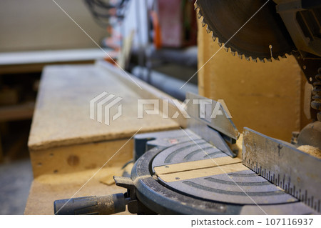 close up of a carpenter screwed a hinge on a wooden plank. close up of a carpenter screwed a hinge on a wooden plank. 107116937