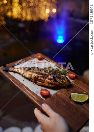 Tray with tasty grilled dorado fish on wooden background 107116948