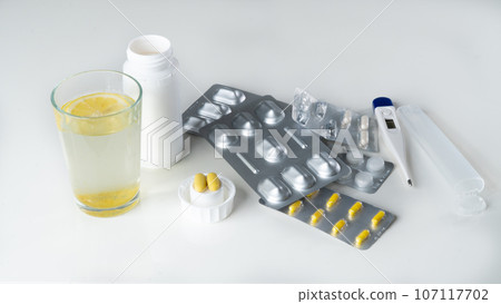 Medicines for treatment - tablets, pills, thermometer, water with lemon 107117702