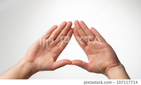 The man's palms are folded in a triangle on a white background 107117714