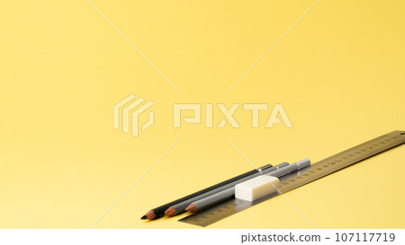 Simple pencils, ruler and eraser on a yellow background Simple pencils, ruler and eraser on a yellow background 107117719