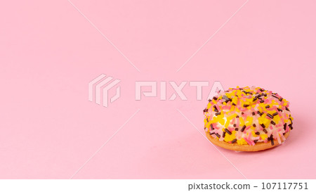 Cake with multi-colored confectionery dressing on a pink background Cake with multi-colored confectionery dressing on a pink background 107117751