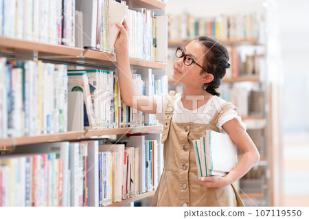 A girl choosing a book 107119550