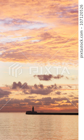 Panorama of St. Elmo Breakwater Lighthouse with the rising sun and colorful clouds. Panorama of St. Elmo Breakwater Lighthouse with the rising sun and colorful clouds. 107120526