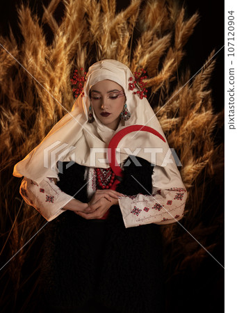 Woman as motanka . Traditional costume. Symbolism, ancient magic, force of nature, cosplay. Woman with sickle Woman as motanka . Traditional costume. Symbolism, ancient magic, force of nature, cosplay. Woman with sickle 107120904