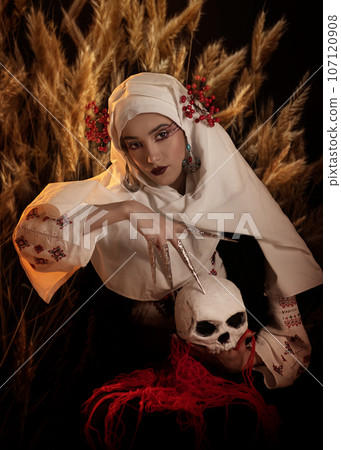 Woman as motanka . Traditional costume. Symbolism, ancient magic, force of nature, cosplay. Witch making magic ritual with skull 107120908