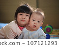 Cute Asian siblings looking at camera and smiling 107121293