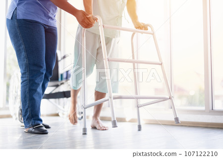 Patient muscle recovery walking training practice using walker with physiotherapist care help support Patient muscle recovery walking training practice using walker with physiotherapist care help support 107122210