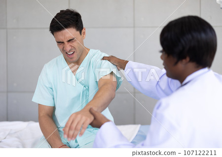 Patient sport male meeting physiotherapist doctor for muscle joint pain physical therapist recovery in hospital clinic Patient sport male meeting physiotherapist doctor for muscle joint pain physical therapist recovery in hospital clinic 107122211