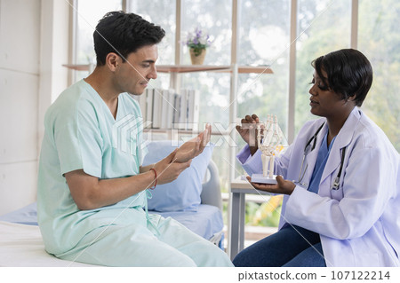 Patient sport male meeting physiotherapist doctor for muscle joint pain physical therapist recovery in hospital clinic 107122214